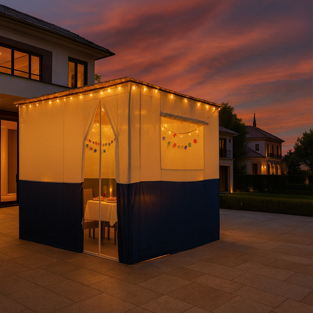 Sukkah with string lights and a table set for dinner against a sunset sky.